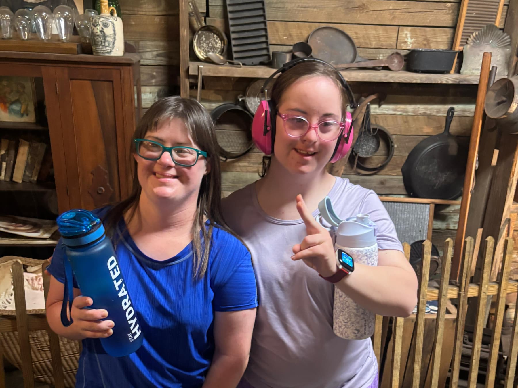 Two Mission ABLE participants smiling together, each holding a reusable water bottle.