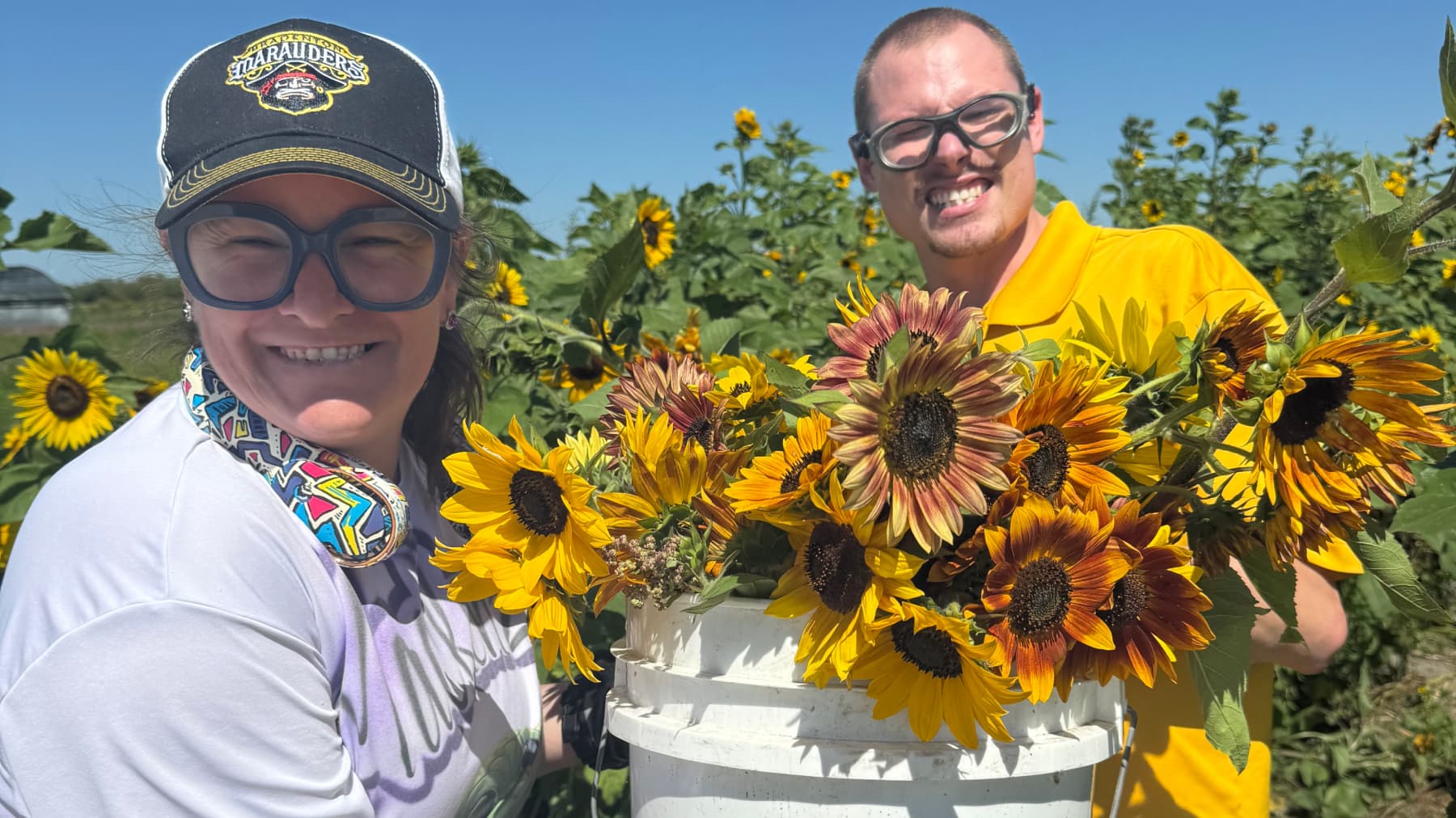 Two participants holding sunflowers picked from the Hunsader field.