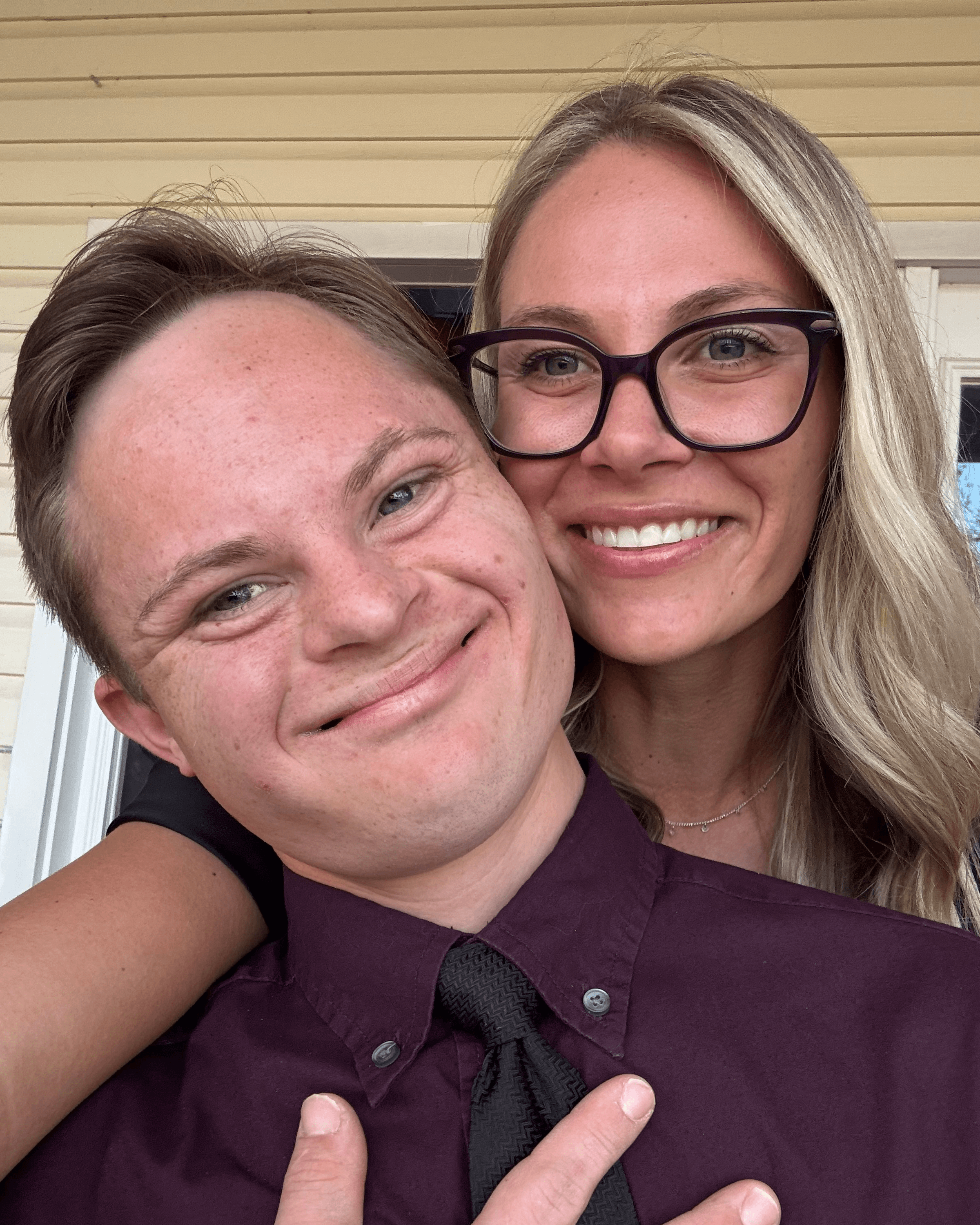 Amanda and her brother Joey smiling together — a warm close-up portrait.